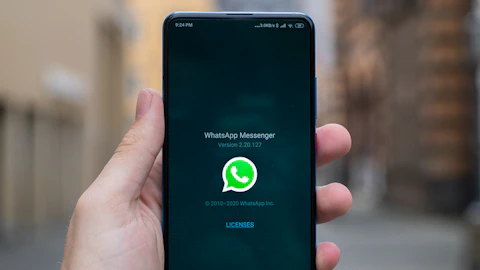 Persona sosteniendo un teléfono inteligente Android negro con ambas manos