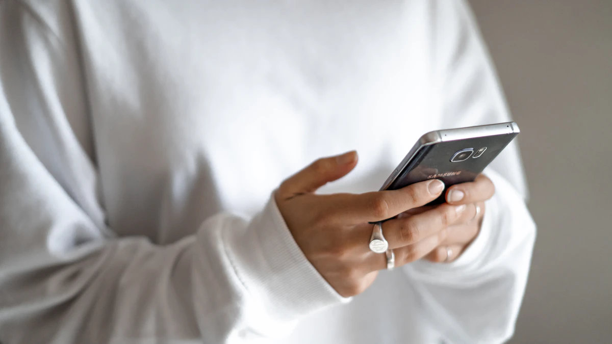 Persona sosteniendo un teléfono inteligente negro