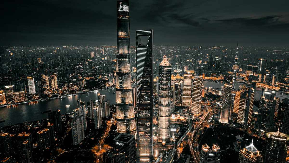 Vista aérea del horizonte iluminado de Shanghái de noche junto al río Huangpu