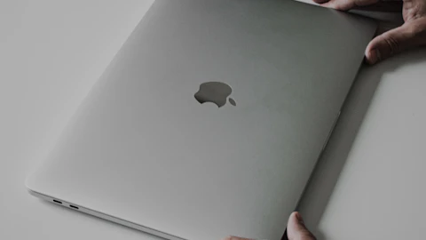 Manos de una persona escribiendo en el teclado de una computadora portátil