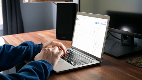 Persona usando una MacBook Pro en una mesa de madera