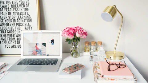 MacBook Air junto a una lámpara de escritorio y libros