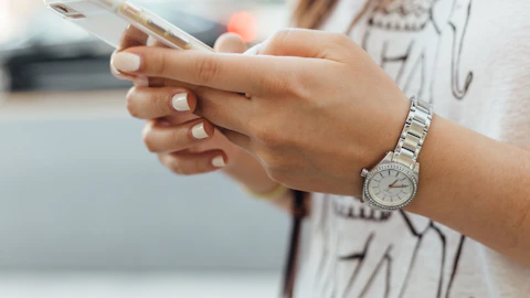 Mujer sosteniendo un iPhone durante el día