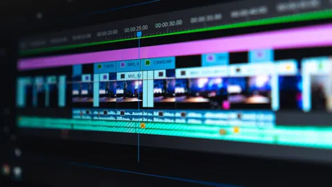 Editor trabajando frente a monitores con una línea de tiempo de video