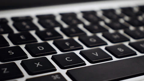 Computadora portátil negra y plateada con el teclado iluminado sobre un escritorio