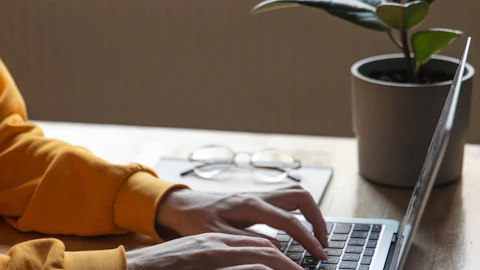 Persona escribiendo en el teclado de una computadora portátil
