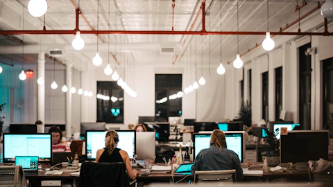Personas sentadas frente a la computadora en un espacio de trabajo